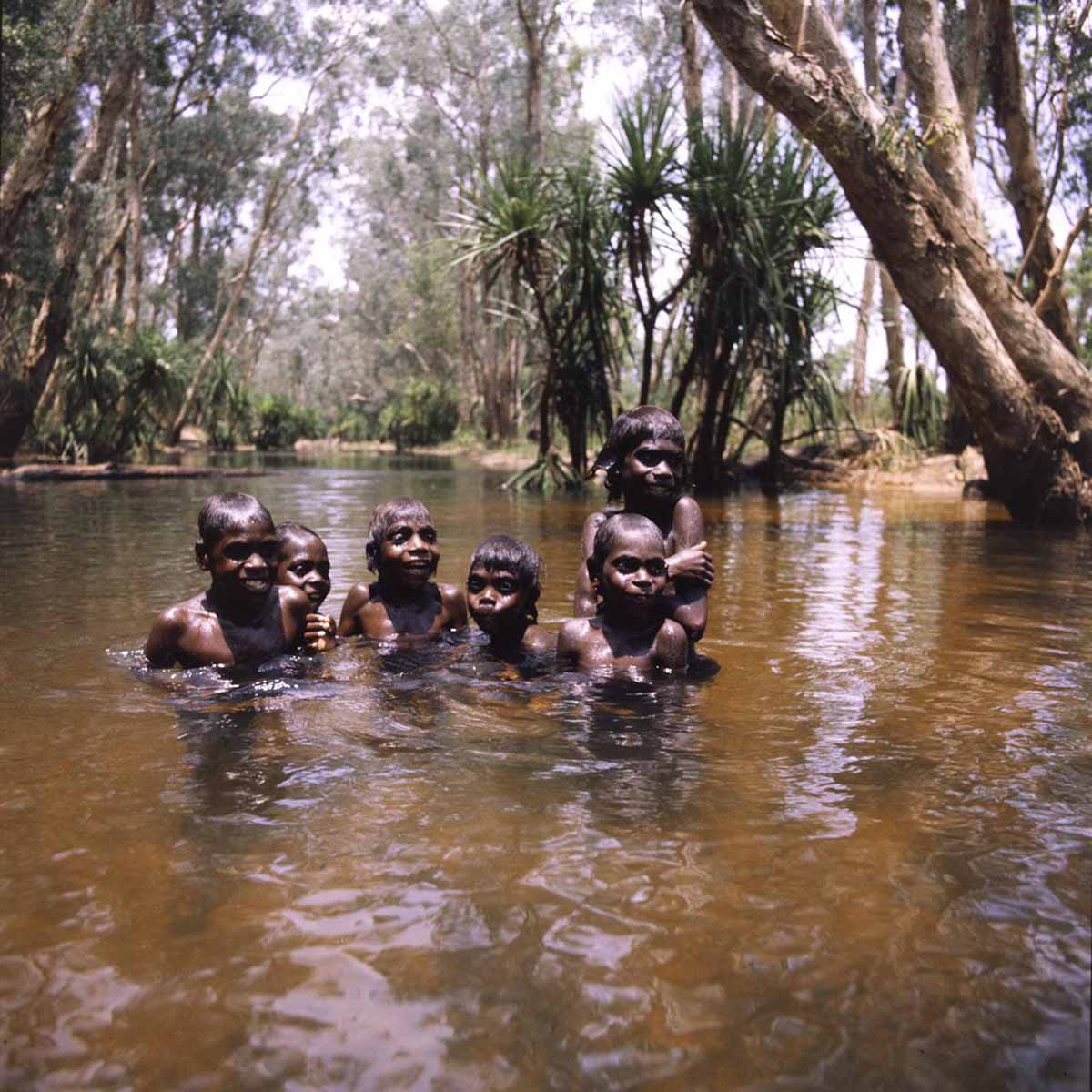 Boys-swimming_Mormega_A8598-AK5-3-80-13_1200 Six Aboriginal boys in a waterhole shaded by pandanus and other trees